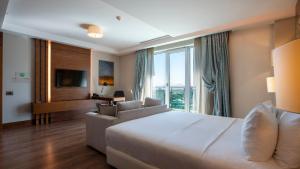 a bedroom with a large white bed and a couch at Holiday Inn Ankara - Cukurambar, an IHG Hotel in Ankara