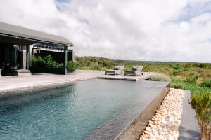 a swimming pool in front of a house at Perivoli Lagoon House in Stanford