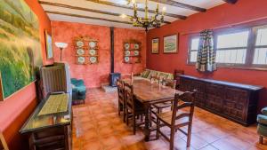 uma sala de jantar com uma mesa de madeira e cadeiras em La Carrasca I Priego de Córdoba by Ruralidays em Priego de Córdoba