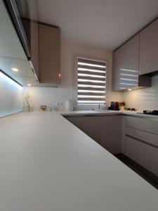 a kitchen with brown cabinets and a white counter top at App 5 pers, parking, 3mn RER A, 40 mn du centre de Paris, Cergy le Haut in Cergy