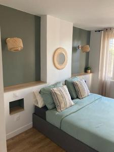 een slaapkamer met een blauw bed met kussens erop bij L'Appartement Vert in Douai