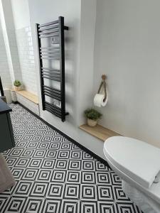 baño con aseo y suelo blanco y negro en L'Appartement Vert, en Douai