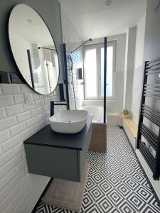 y baño con lavabo y espejo. en L'Appartement Vert, en Douai