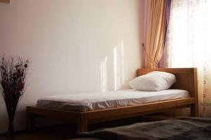 1 cama con almohada en un banco de madera en una habitación en Cazare ANIMA en Baia Mare