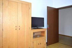 een kamer met een televisie op een houten kast bij Cazare ANIMA in Baia Mare
