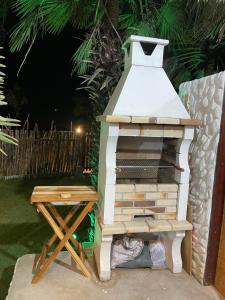 a outdoor grill with a picnic table next to a fence at Casa Mangue in Macapá