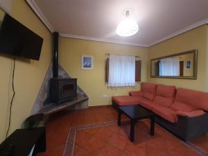 un soggiorno con divano e camino di Apartamentos Esqueiro a San Cosme