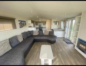 ein Wohnzimmer mit einem Sofa und einem Tisch in der Unterkunft Lyons robin hood lodge Rhyl in Rhyl