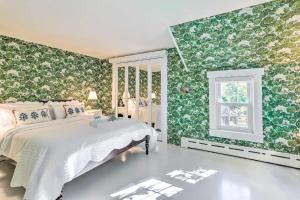 um quarto com paredes florais verdes e uma cama em The Blue Scallop Dennis Cottage - Walk to Beach! em Dennis