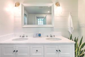 a white bathroom with two sinks and a mirror at Walkable Dennis Cottage The Blue Scallop in Dennis +16 photos