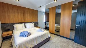Çimentepe Residence Deluxe في بودروم: غرفة فندق عليها سرير وفوط