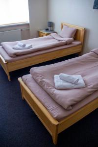 two beds in a room with towels on them at Olimpija Hotel & SPA in Daugavpils