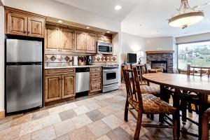 a kitchen with wooden cabinets and a table with chairs at Steamboat Resort Villas 608 in Steamboat Springs