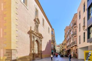 a street in a city with people walking on the sidewalk at Under the Olive Trees in Historic Center of Malaga in Málaga