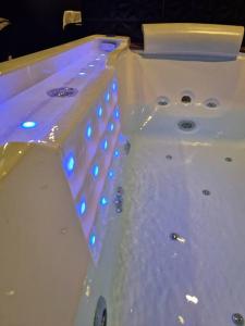 a white bath tub with blue lights on it at Suite Coquine avec jacuzzi YaoSpa60 