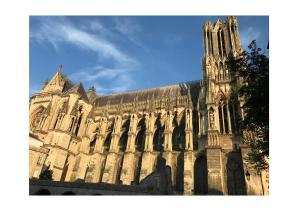 a large stone building with a clock tower at Suite Clovis - 1 in Reims