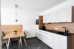 a kitchen with white cabinets and a wooden table at Berg Aparts Faschina Top 7 in Fontanella