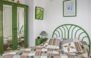 een slaapkamer met een groen bed met kussens erop bij Amazing Home In Kerlouan-neiz Vran With House Sea View in Trérohant