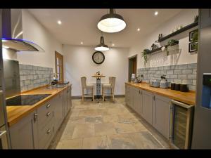 a large kitchen with a table in the middle at Luxury Waddington Cottage, Ribble Valley in Waddington