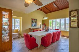 a dining room with a table and red chairs at Villa Bella Mare Aruba - Steps to the beach in Palm-Eagle Beach