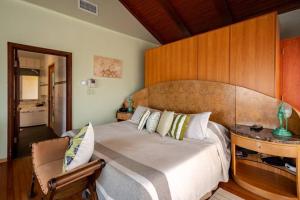 a bedroom with a large bed with a wooden headboard at Villa Bella Mare Aruba - Steps to the beach in Palm-Eagle Beach +27 photos
