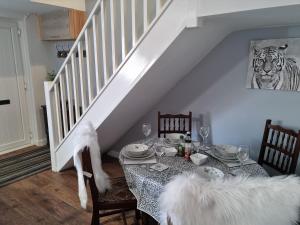 a dining room with a table with chairs and a tiger picture at Dare Valley Cottage Ex miners cottage Near Zip World Pen y fan Waterfalls in Aberdare