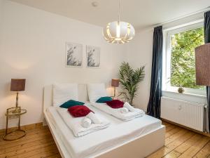 Cama blanca en habitación con ventana en Fabelhafte Apartments zum wohlfühlen mit JUNIK Apartments en Duisburg