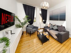 a living room with a couch and two chairs at Fabelhafte Apartments zum wohlfühlen mit JUNIK Apartments in Duisburg