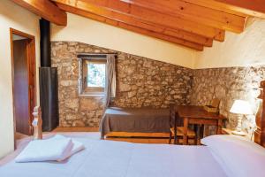 een slaapkamer met een bed, een tafel en een raam bij Casa Rural El Callís in Vall de Bianya