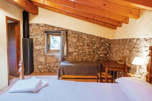 a bedroom with a bed and a table and a window at Casa Rural El Callís in Vall de Bianya