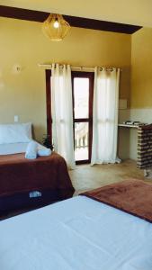 a hotel room with two beds and a window at Vila Samin Moitas in Praia de Moitas