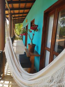 a hammock on the front porch of a house at Vila Samin Moitas in Praia de Moitas