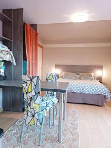 Gîte des Douces'Eure في Cierrey: غرفة نوم بسرير وطاولة وكراسي