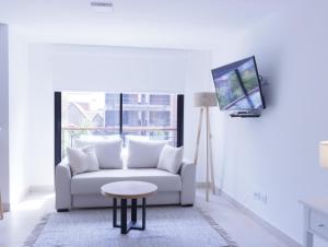 een witte woonkamer met een bank en een tafel bij A Departamento monoambiente a pasos del mar in Mar del Plata