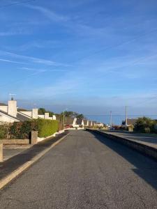 an empty street in a town with a blue sky at Benllech Sea View bungalow, Dog Friendly sleeps 6 in Benllech