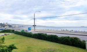 vistas a una carretera y al océano con luz de la calle en Departamento Frente al Mar, en Viña del Mar