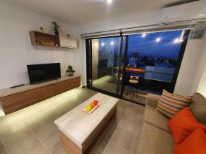 sala de estar con sofá y ventana grande en Departamento Vista a Cordillera Premium en Godoy Cruz