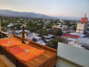 dos copas de vino sentadas en una mesa en un balcón en Departamento Vista a Cordillera Premium en Godoy Cruz