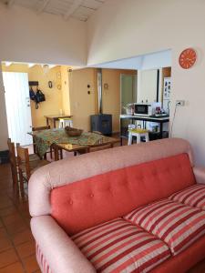 a living room with a red couch and a table at La Casa de Sibel in Chapadmalal