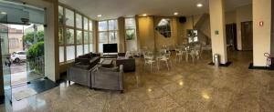 een lobby met een woonkamer met tafels en stoelen bij Bravo City Hotel Sao Carlos in São Carlos