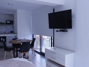 a bedroom with a table and a tv on a white cabinet at B Monoambiente en Mar del Plata a metros del mar in Mar del Plata