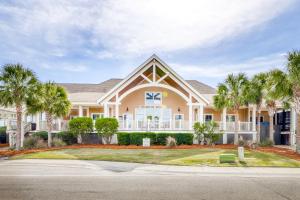 a large house with palm trees in front of it at Pelican Watch in Seabrook Island