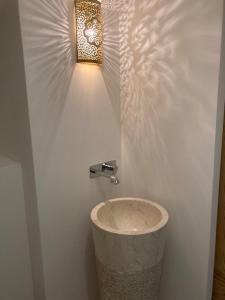 a bathroom with a light on a white wall at CHAMBRES DES EAUX 28 "baptistine" in Sarcey