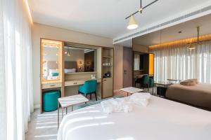 LUSTER Hotel في لشبونة: غرفة في الفندق مع سرير وغرفة طعام