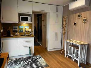 een keuken met witte kasten en een aanrechtblad bij Le Lodge in Belin-Beliet