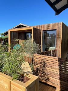 een houten terras met een tuin in een huis bij Le Lodge in Belin-Beliet +8 foto's