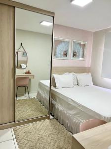 um quarto com uma cama grande e um espelho em ilha confort, aconchegante ideal para casal, famílias e amigos em São Luís