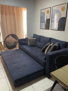 um sofá azul com almofadas numa sala de estar em ilha confort, aconchegante ideal para casal, famílias e amigos em São Luís