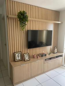 uma sala de estar com televisão numa parede de madeira em ilha confort, aconchegante ideal para casal, famílias e amigos em São Luís
