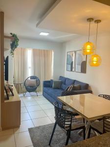 uma sala de estar com um sofá azul e uma mesa em ilha confort, aconchegante ideal para casal, famílias e amigos em São Luís